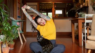 Woman doing yoga with cat