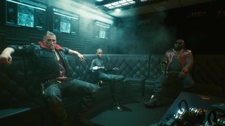 Jackie and Dex sat on a sofa in Cyberpunk 2077.