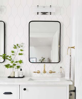 Monochrome bathroom with mirror above countertop and vertical white tiling on backsplash