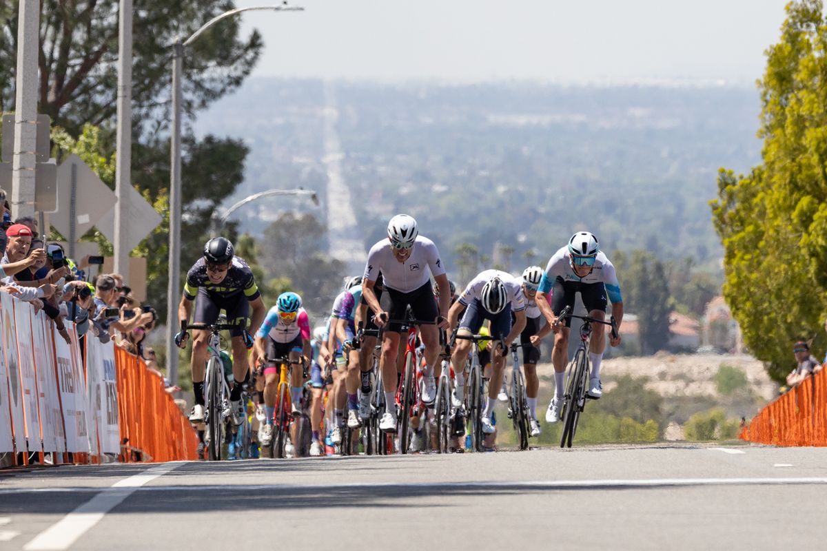 The announcers and spectators were surprised when three riders, side-by-side, appeared over the crest of the baseline climb.