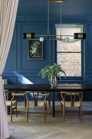 Dark blue dining room with small painted window