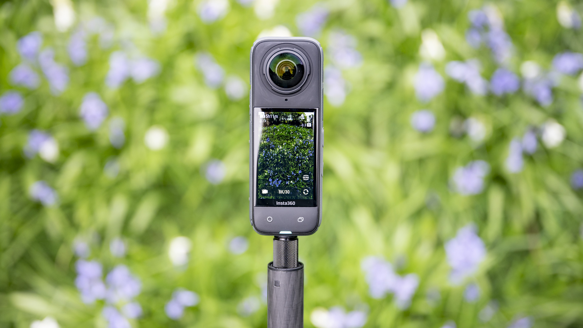 Insta360 X4 360 degree camera outdoors with vibrant grassy background