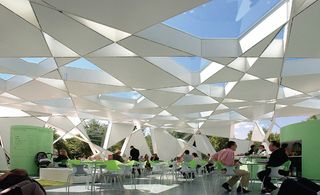 A metal roof in geometrical shapes covers the cafeteria. The light comes in through some of the openings in the roof.