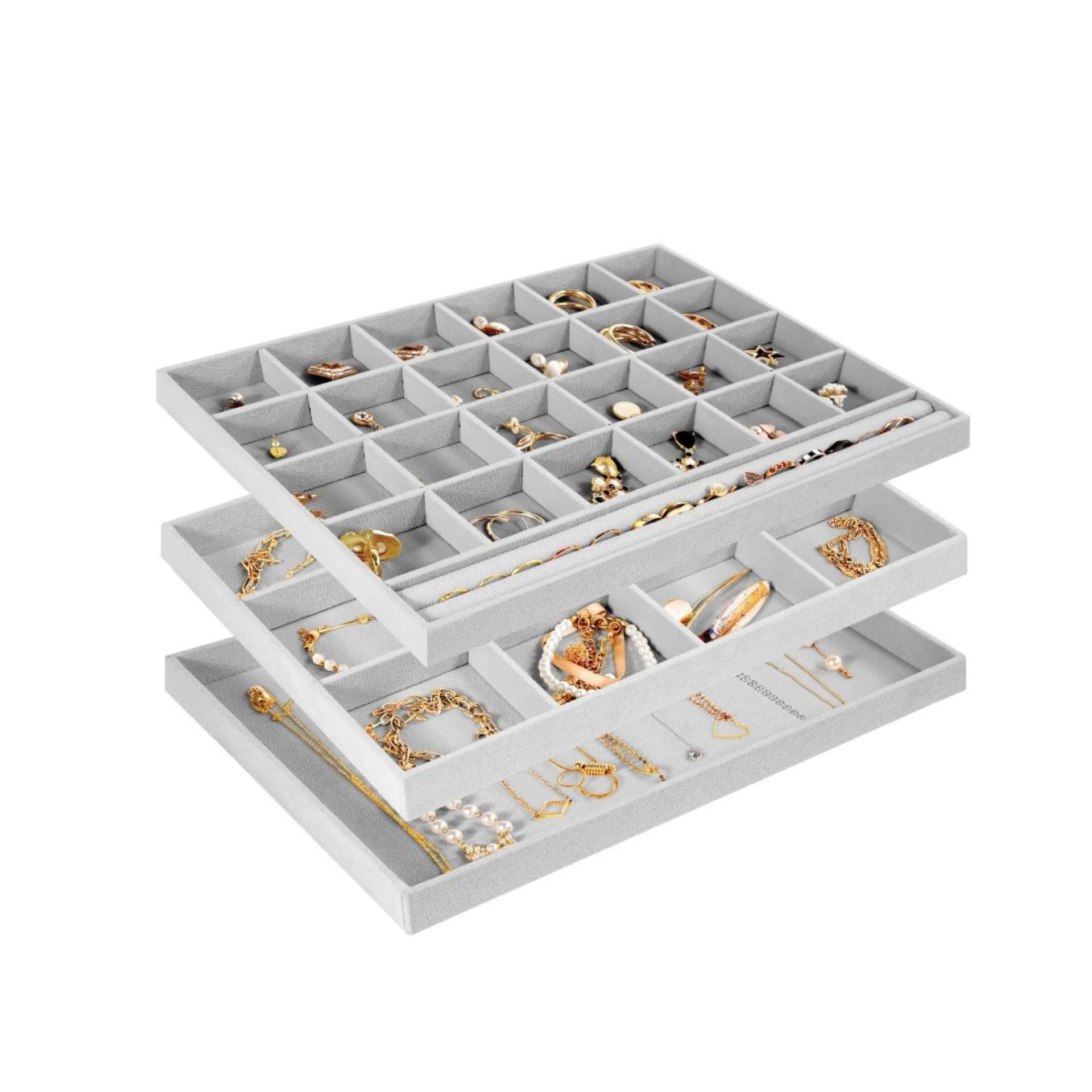 Tiga pembagi laci abu-abu dengan perhiasan di dalamnya