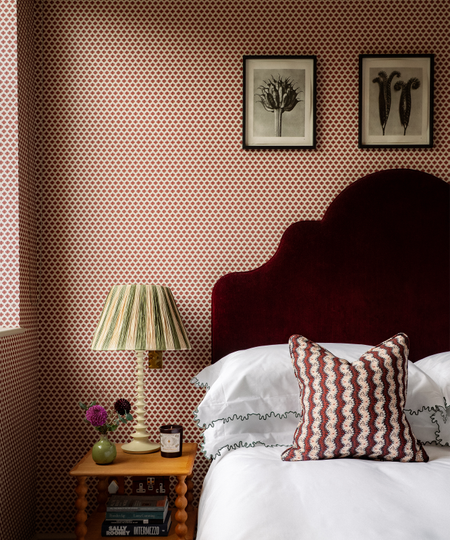 bedroom with red and white wallpaper and burgundy headboard