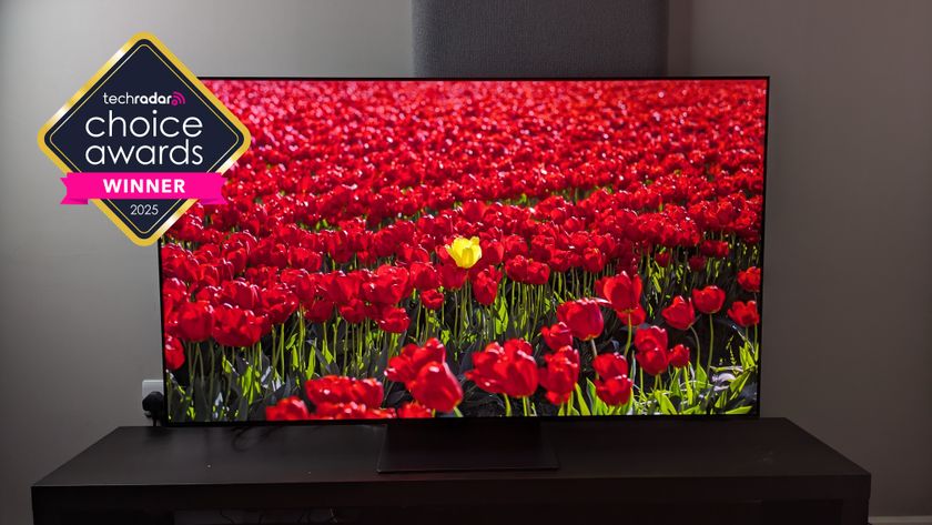 The Samsung S95F TV showing a field of flowers, with the TechRadar Choice Awards Winner logo over it