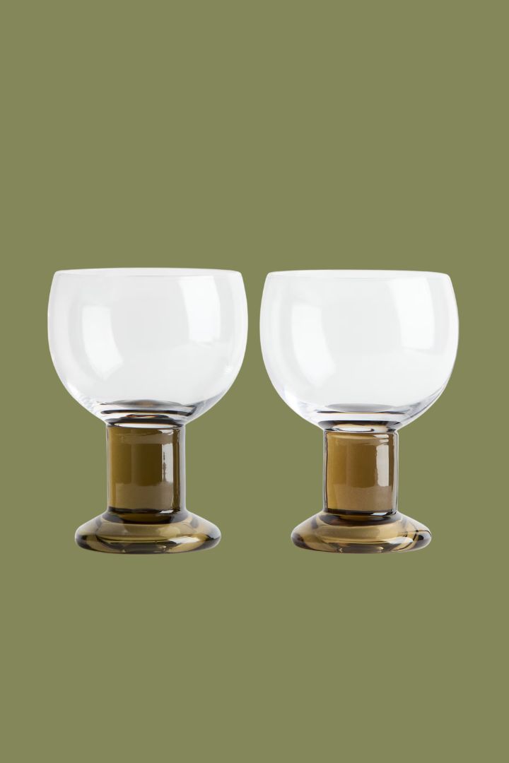 2-pack mouth-blown wine glasses against green background.