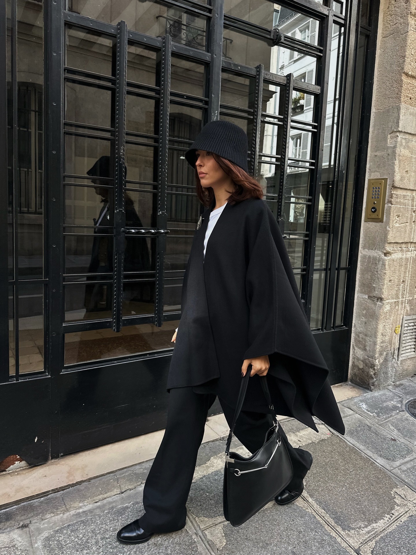 A woman in Paris wearing a stylish, all-black, winter outfit