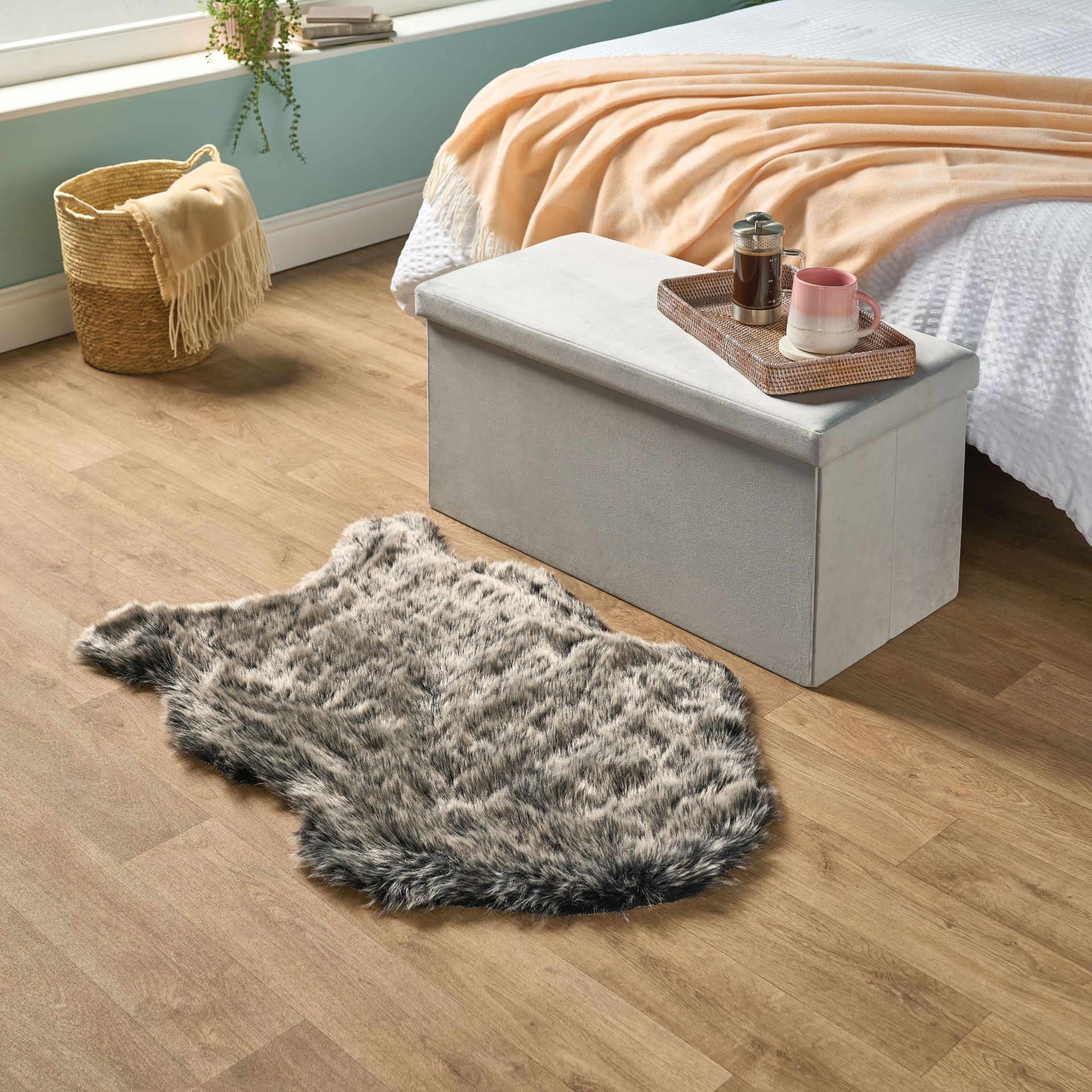 Faux fur rug and velvet ottoman storage box in bedroom