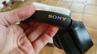 Sony ULT Wear over-ear headphones in hand showing headband and lenticular logo