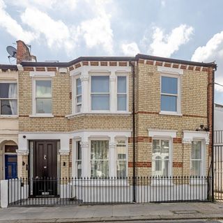 two story brick wall house with white window brown door