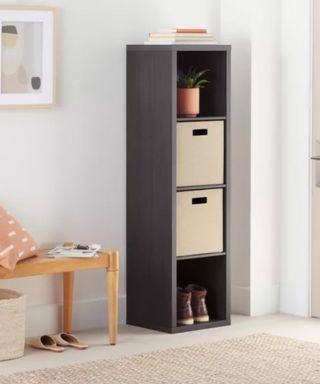 A tall black storage unit with beige boxes in it