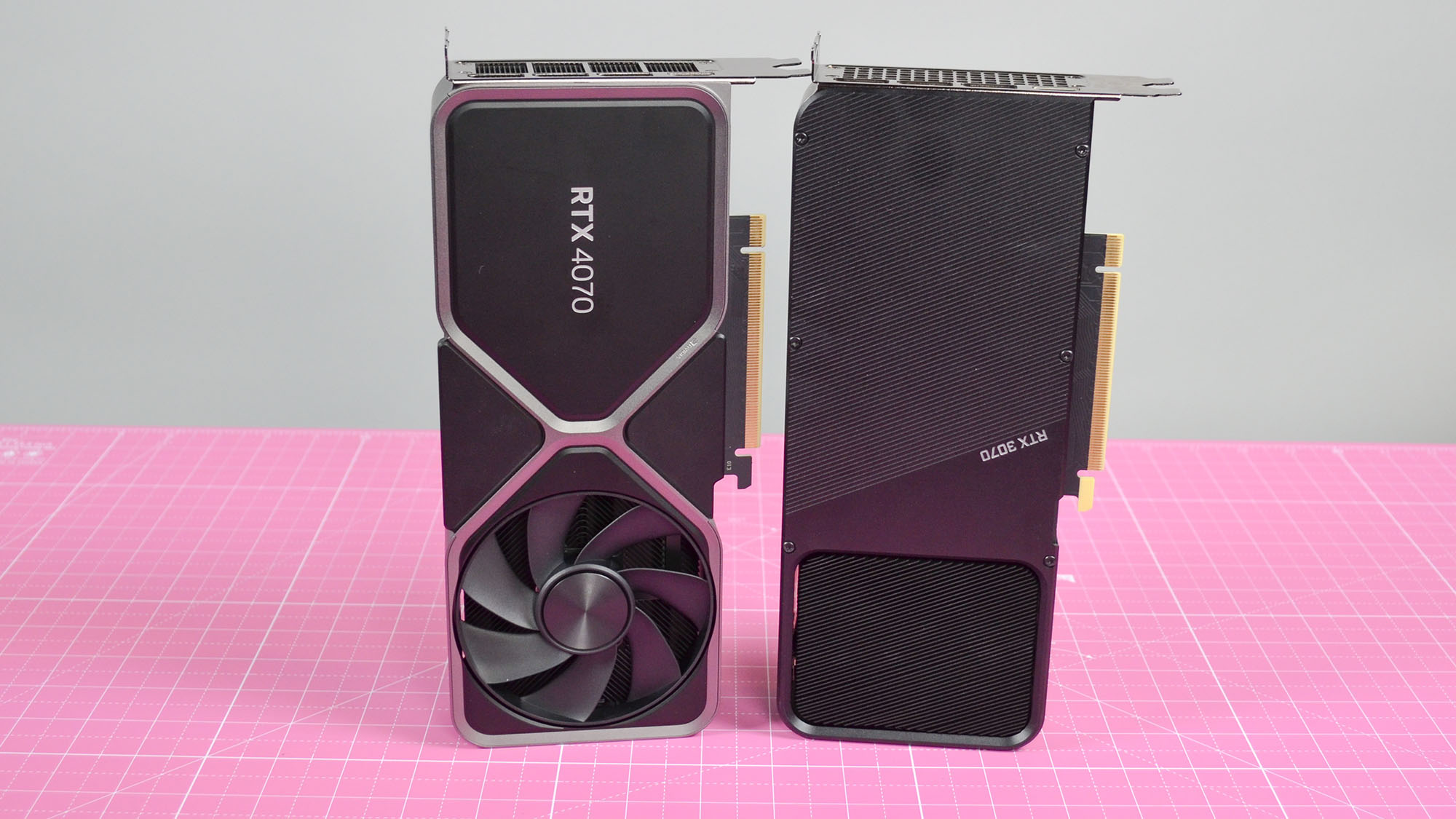 An Nvidia GeForce RTX 4070 graphics card standing upright next to the RTX 3070