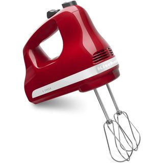 KitchenAid hand mixer in empire red on a kitchen countertop