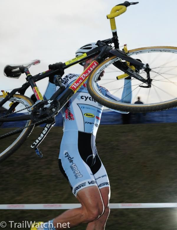 Adam Myerson lifting his bike high over the barriers