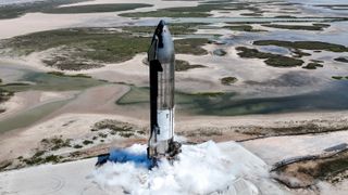 spacex's shiny silver ship 25 starship prototype endures an engine-pump test at starbase in south texas, with sandy, water-filled pools in the background
