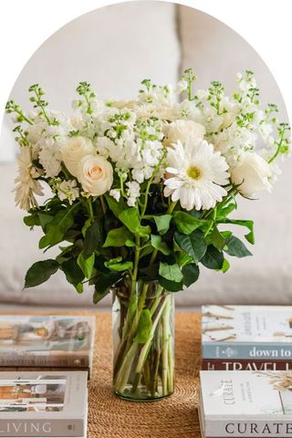 A bouquet of white pet-safe flowers in a clear vase.