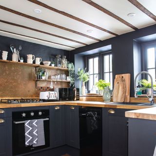 Dark kitchen colour scheme with wooden worktops and appliances on display