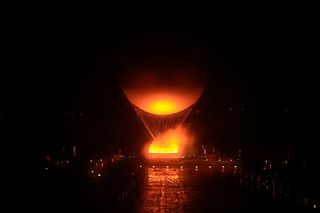 The Olympic cauldron's flame is lit beneath the balloon