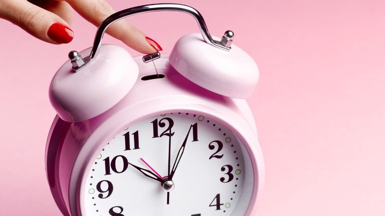 Pink alarm clock on pink background
