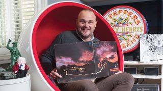 A photograph of Al Murray holding a Genesis record
