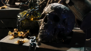 An image of a skull lying among occult items and gems.