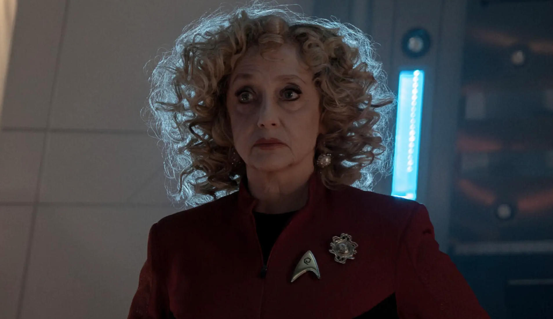 a woman with bushy blonde hair in a sci-fi tv show