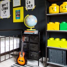 A black-painted kid's room with a Lego display