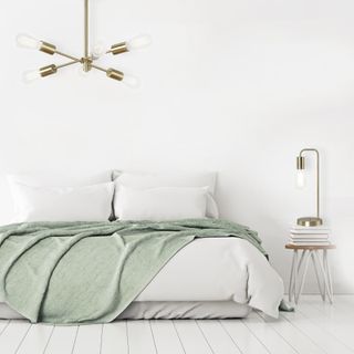 bedroom with white wall and brass ceiling light and bedside lamp