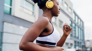 Woman wearing headphones and sports bra
