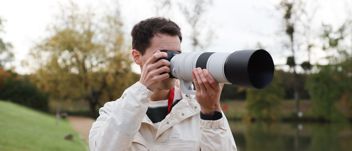 Canon RF 200-800mm f/6.3-9 IS USM lens on a Canon EOS R5 camera held in up to a man&#039;s face