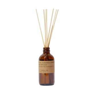 A brown reed diffuser bottle with wooden reeds in it