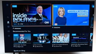 The home screen on Sling TV shows cable news options on a wall-mounted TV