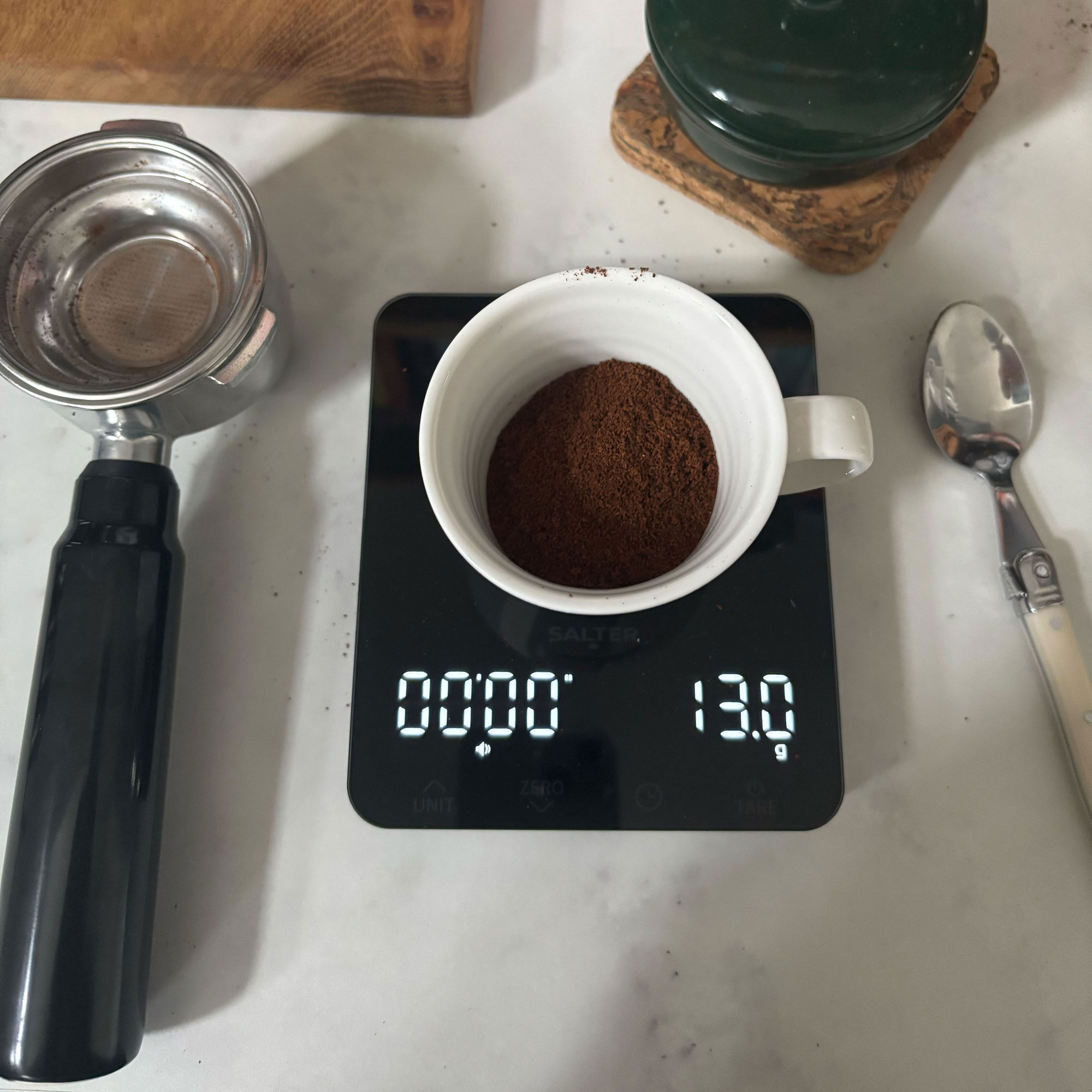 Espresso cup filled with coffee grounds on a scale