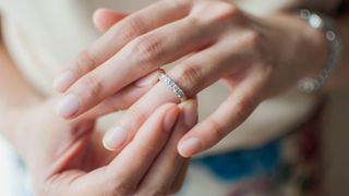 A close-up view of a woman wearing a wedding ring