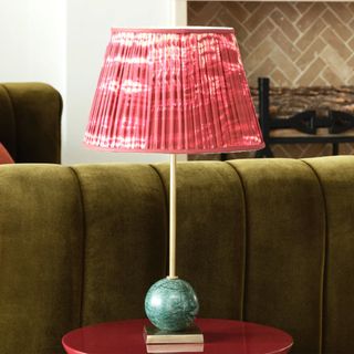 Green marble table lamp on a red side table in a living room