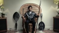 André Holland as Huey P. Newton in a wicker chair in The Big Cigar