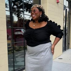 Chichi wears gray skirt, black top, cheetah print top, red shoes, and black slingback. 