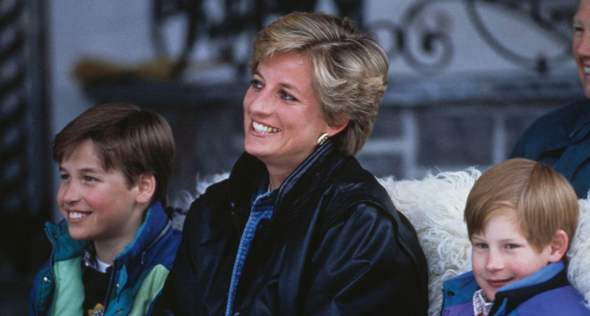 Princess Diana sitting in a sleigh with Harry and William