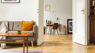 Living room and study with chevron-patterned wooden floor