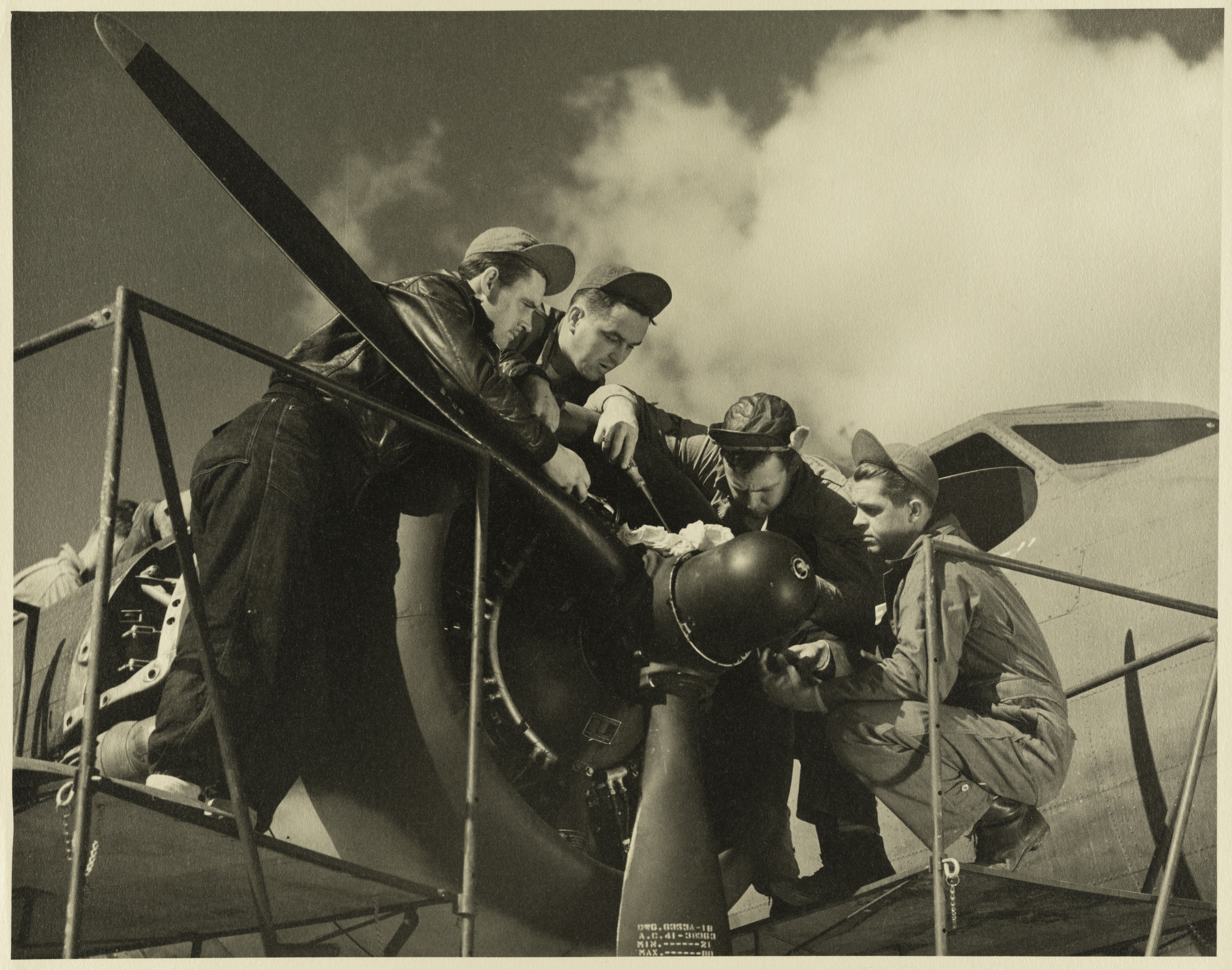 Sepia image of men mending a plane during the Second World War