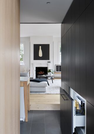 black and wood kitchen with view through to white living room