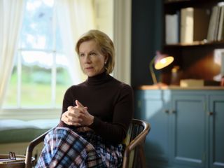 Dr Helena Goldberg (Juliet Stevenson) in her office, sitting in a mahogany armchair and looking concerned