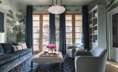 green living room with botanical wallpaper and blue sofas by Marie Flanigan 