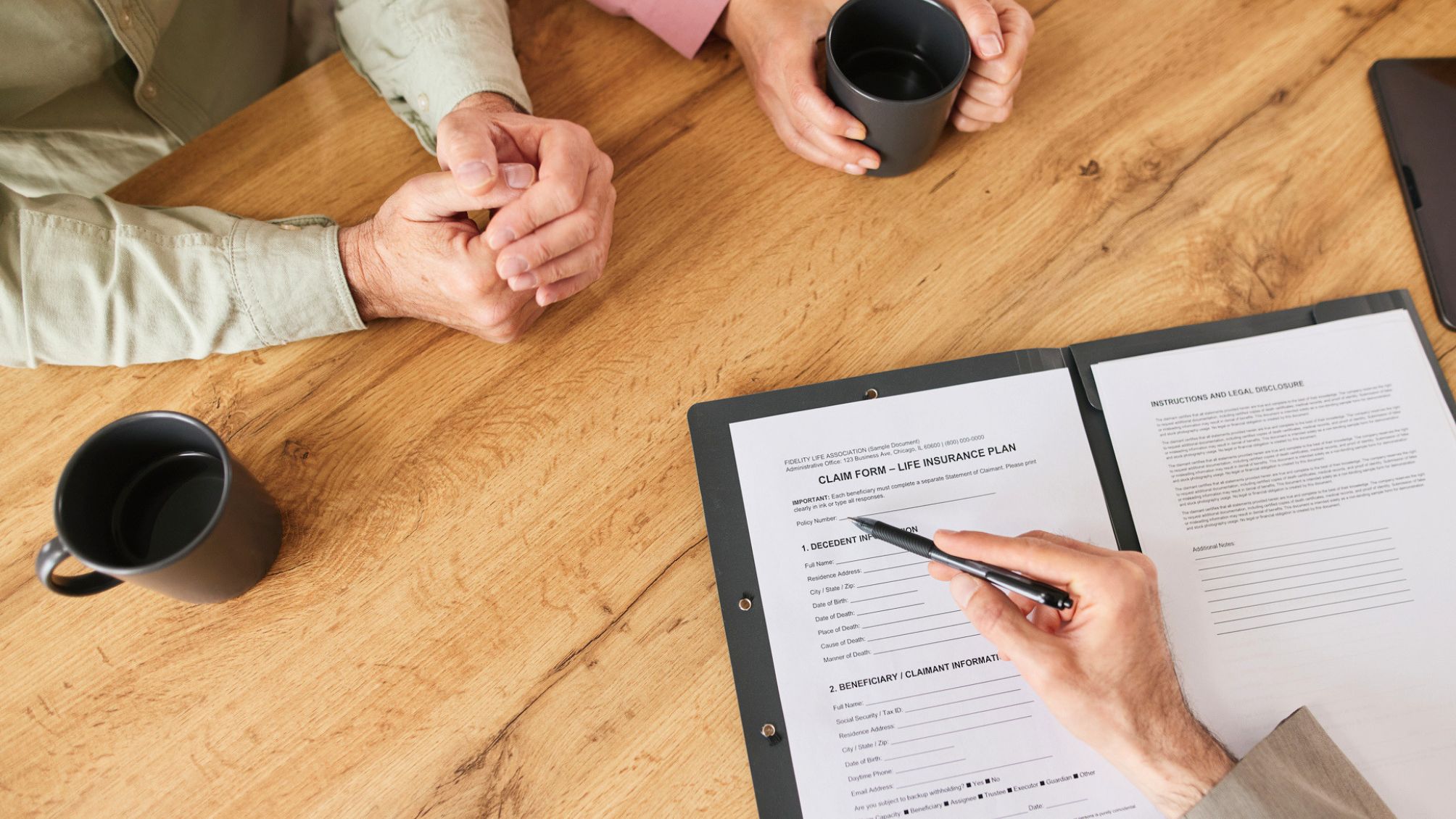Life insurance agent assisting senior couple with claim form