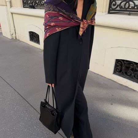 Creator @mimixn wearing a long black coat and colourful shawl