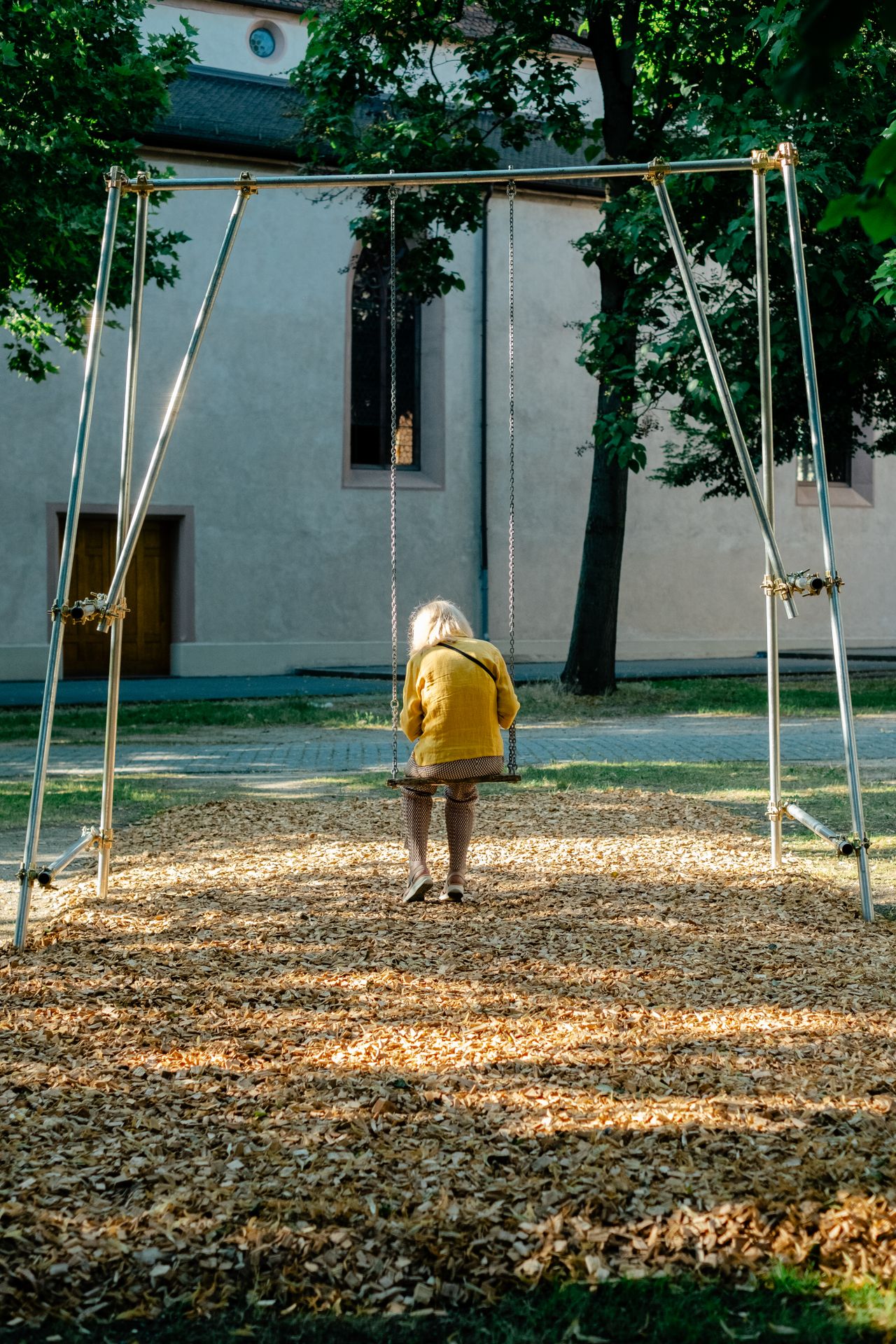 A series of lifestyle images depict people at leisure and play in a Swiss town bathing in sunshine, whether enjoying the weather near the river bank or abstract painting murals at an art fair.