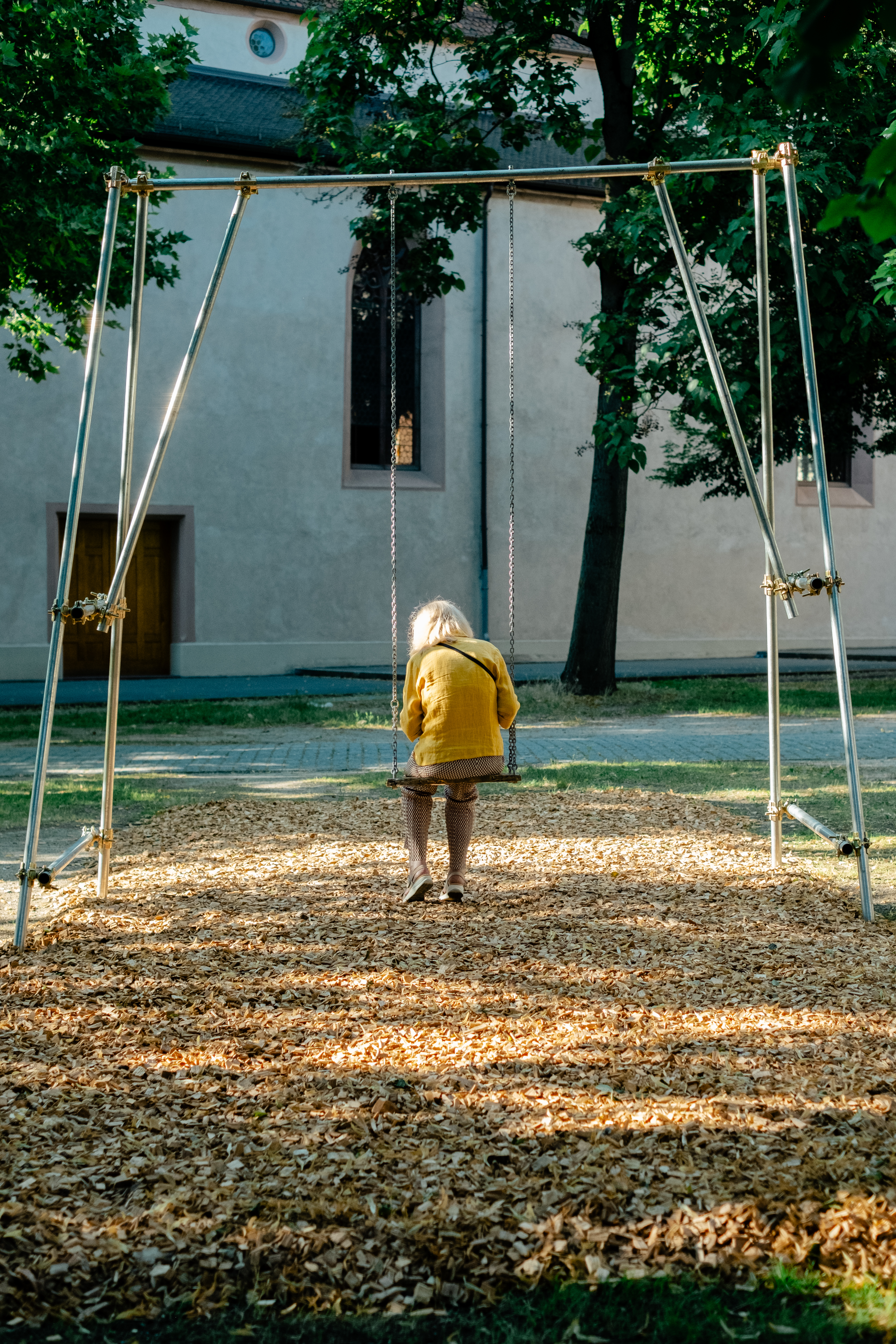 A series of lifestyle images depict people at leisure and play in a Swiss town bathing in sunshine, whether enjoying the weather near the river bank or abstract painting murals at an art fair.