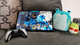 Verbatim portable monitor with Overwatch 2 character select screen on display next to two Squishmallow frogs