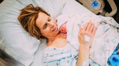 Cecile Raynek holding her granddaughter in hospital bed